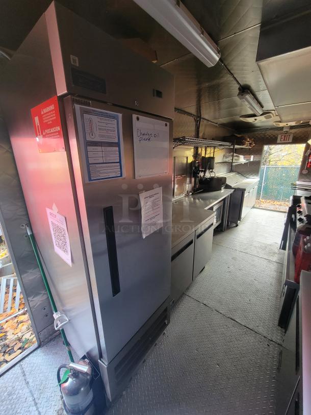 2021 24' Quality Kitchens mobile food trailer interior with stainless steel appliances, dual Imperial fryers, gas griddle, and Arctic Air refrigeration.