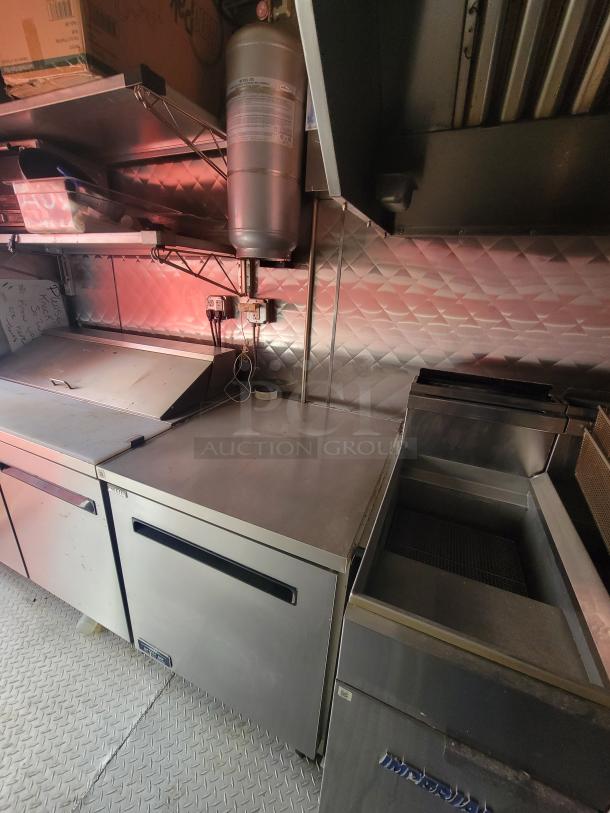 2021 24' Quality Kitchens mobile food trailer interior, stainless steel surfaces, Arctic Air refrigeration, Imperial fryer visible.