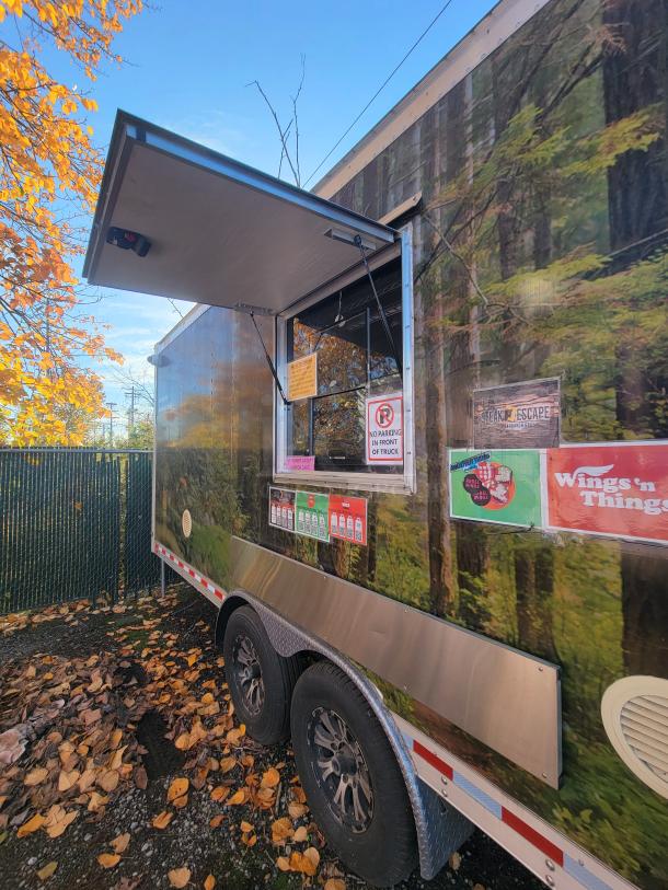 2021 24' Quality food trailer, forest wrap, tandem axle, side service window, exterior signage, excellent condition.