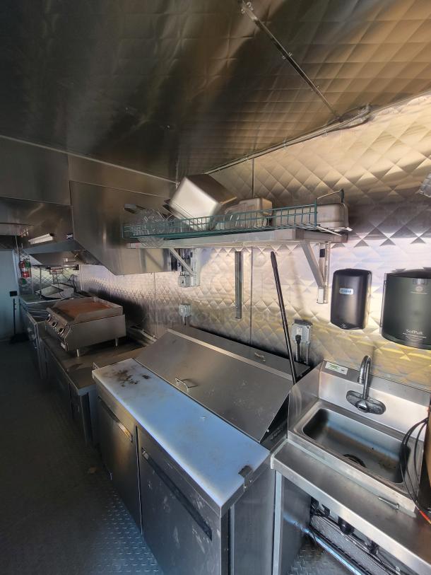 2021 24' Quality food trailer interior, featuring stainless steel kitchen with gas griddle, deep fryers, Arctic Air refrigeration, sinks.