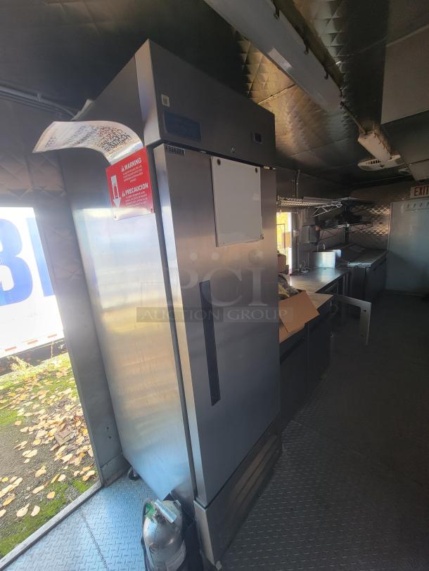 2021 Quality 24' food trailer interior with stainless steel appliances, Arctic Air freezer, fire suppression system, and kitchen setup.