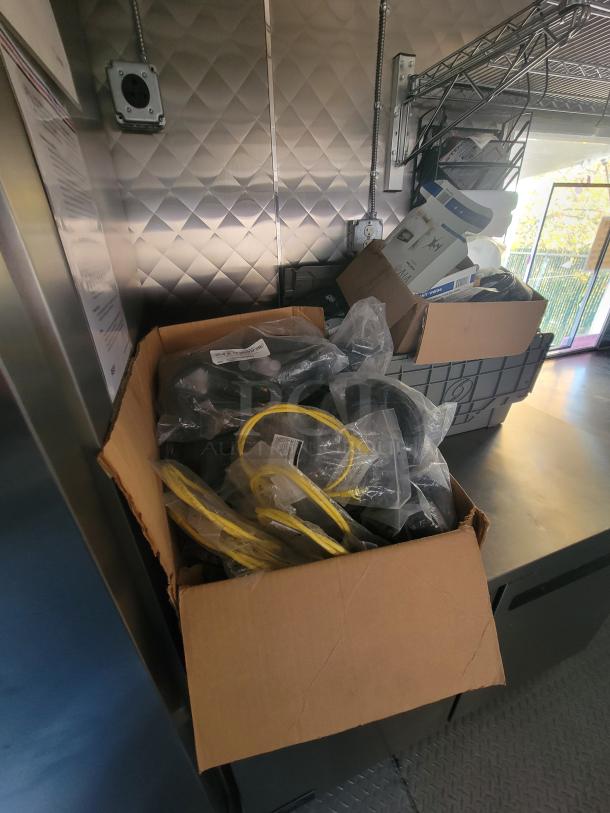 Interior of 2021 Quality 24' food trailer showing stainless steel walls, shelving, and unpacked boxes on counter.