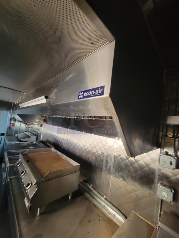 2021 24' Quality Food Trailer interior with Econ-Air exhaust hood, gas griddle, stainless steel build, and power outlets.