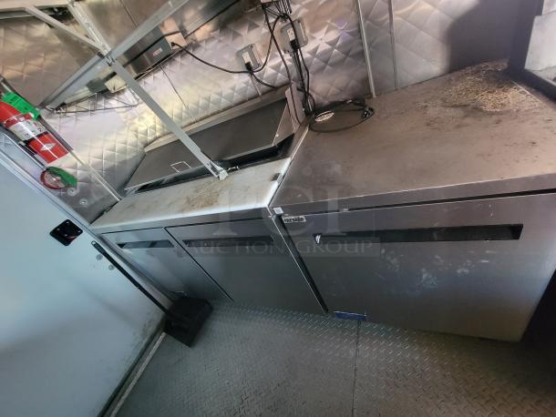 2021 Quality 24' food trailer interior with stainless steel surfaces, Arctic Air refrigeration units, and safety systems.