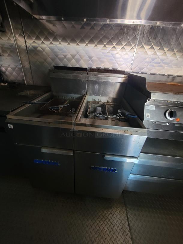 2021 24' Quality food trailer interior showing two Imperial commercial gas deep fryers and a gas flat-top griddle. Stainless steel build-out.