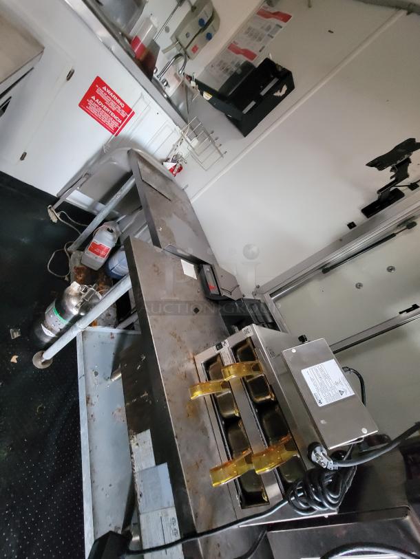 2020 Rock Solid 16' mobile trailer interior, featuring high-end commercial kitchen equipment, stainless steel counters, sinks, and safety signage.