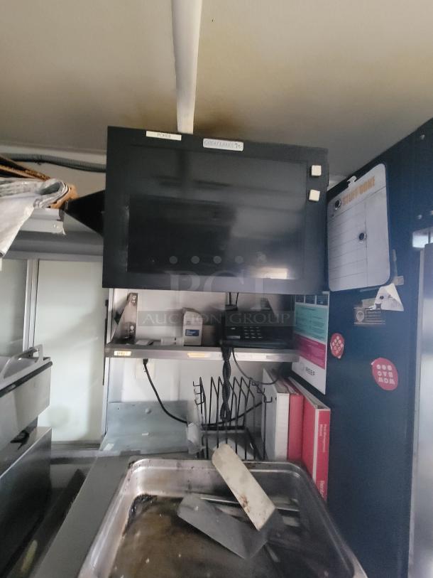 Mobile ghost kitchen interior with shelves, a phone, binders, and a monitor labeled "Great Lakes." Visible signage enhances info.