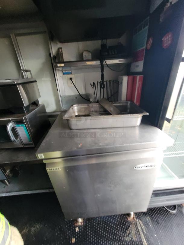 2020 Rock Solid 16' mobile kitchen trailer with Serv-Ware freezer, stainless steel counter, and shelving inside.