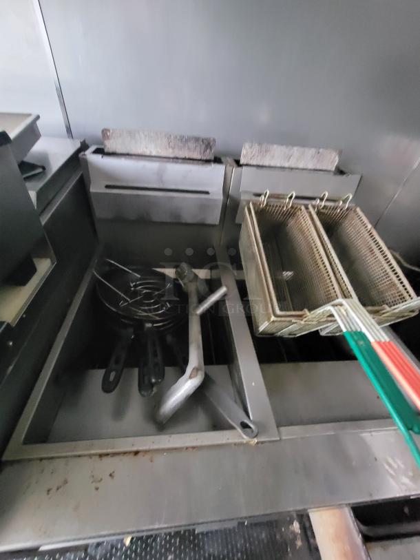 Mobile ghost kitchen interior with Vulcan-style electric fryer, cooking utensils, and commercial exhaust hood.