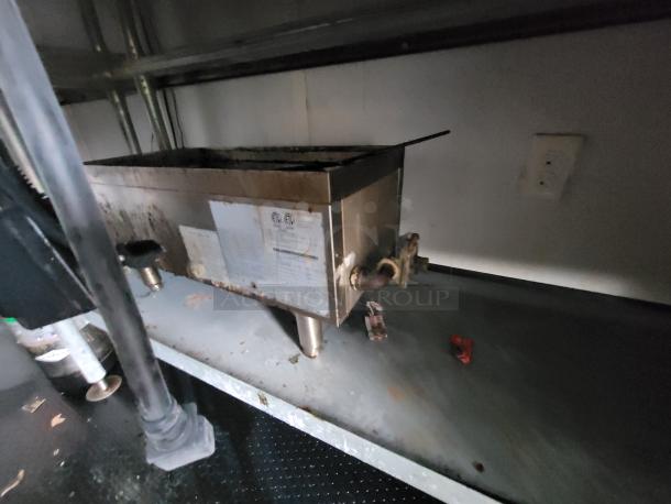 Rustic commercial stainless steel sink in a 2020 Rock Solid 16' mobile trailer with visible plumbing and storage compartments.