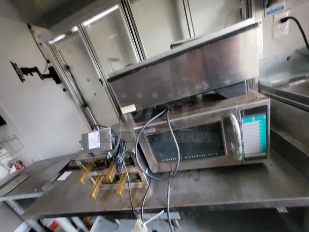 2020 Rock Solid 16' mobile trailer interior with commercial-grade equipment, including a microwave and stainless prep table.
