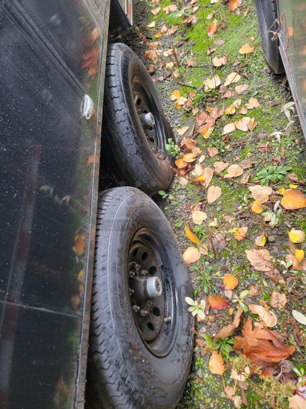 2021 SDG 24' refrigerated trailer, visible axle and tires on grassy surface, autumn leaves scattered around.