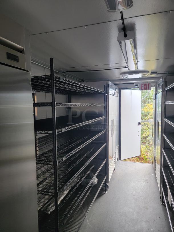 2021 SDG 24' refrigerated trailer interior, featuring chrome wire shelving, stainless steel worktops, and commercial freezers.