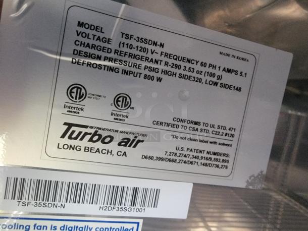 Label inside Turbo Air fridge in SDG refrigerated trailer, showing model TSF-35SDN-N info, voltage, refrigerant type, and certifications.
