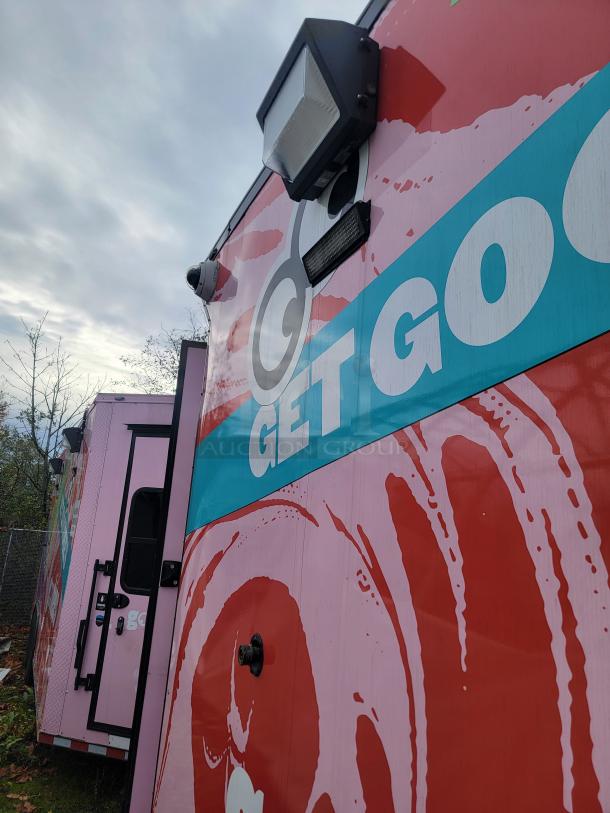 High-volume mobile retail/freezer trailer with vibrant graphics, exterior lighting, security cameras, and access doors, built by SDG in 2021.