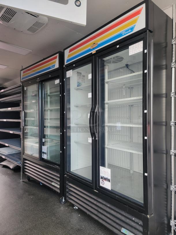 Commercial-grade mobile retail trailer interior with dual True brand glass door freezers, chrome wire shelving, and installed AC unit.