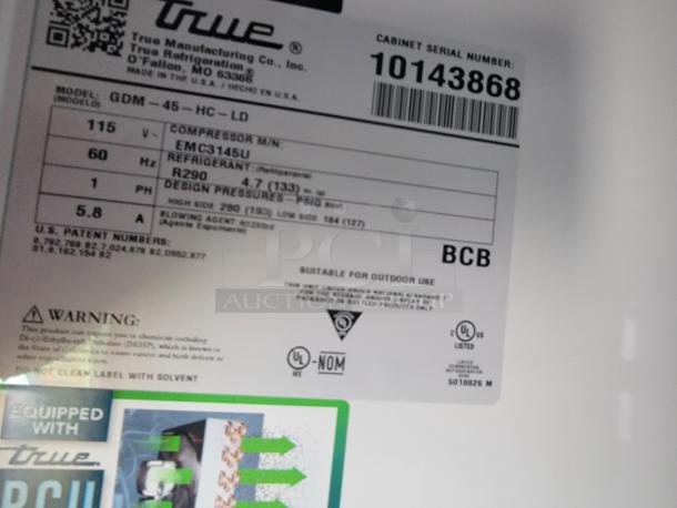 Label on refrigeration unit showing model "GDM-45-HC-LD," 115V, with True Manufacturing branding and serial number 10143868.