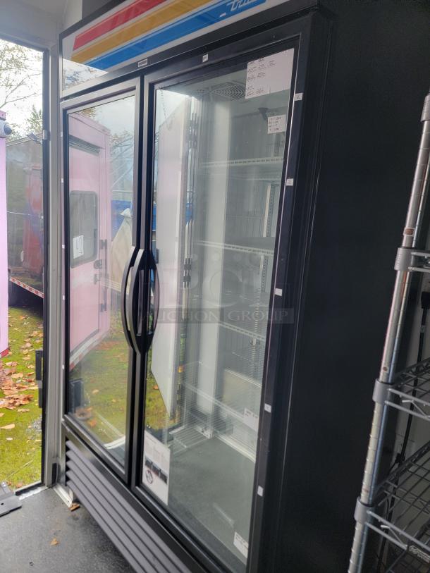 Commercial freezer inside SDG 20 mobile retail trailer. Double glass doors, chrome wire shelving visible, high-end refrigeration.
