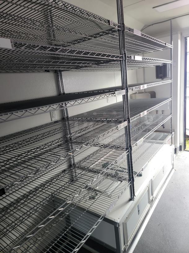 SDG Model 20 mobile retail/freezer trailer interior with chrome wire shelving, built-in storage, and professional setup for retail/food service use.