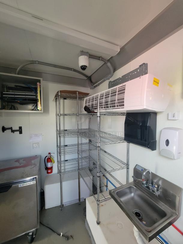 2021 Diamond Cargo Mobile Trailer interior view; features GREE HVAC, metal shelving, Beverage-Air cooler, sink, and dome camera.