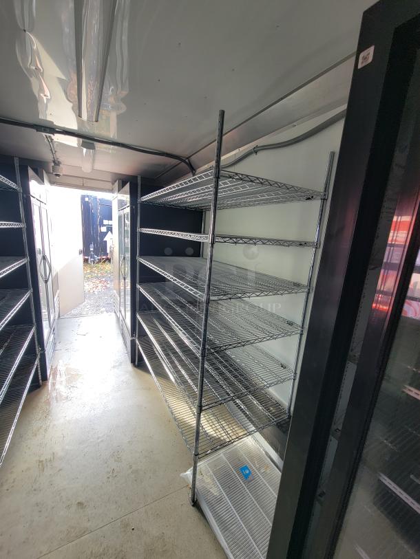 Interior of a 2021 24' Diamond Cargo mobile trailer with metal shelving units, suitable for food service or groceries.
