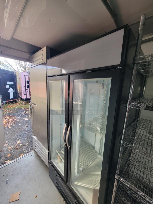 Interior of a 2021 Diamond Cargo Mobile Grocery/Food Trailer with a Beverage-Air glass-door merchandiser and stainless steel cooler.