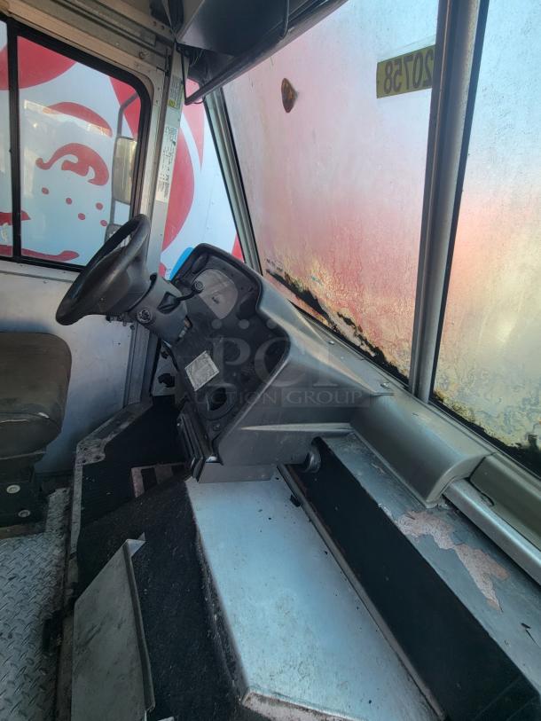 2007 Ford Utilimaster food truck interior, showing driver's seat and dashboard. Visible wear suggests need for restoration. VIN: 1FCKE39L17DB00345.