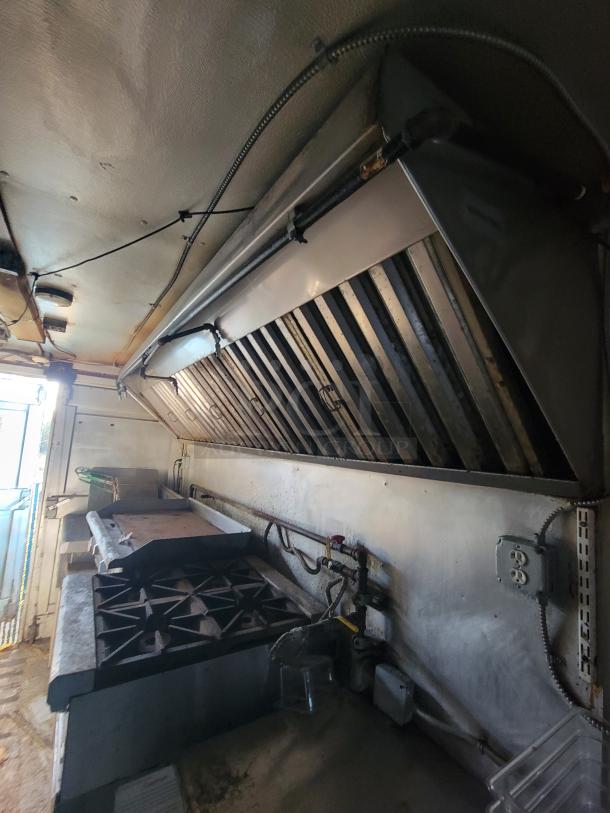 2007 Ford Utilimaster food truck interior with stove, vent hood, and wiring. Heavy-duty kitchen setup, requires restoration.