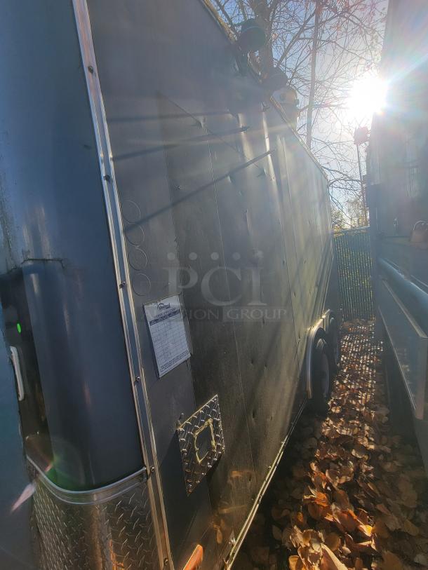 2018 STM 14-Foot Concession Trailer, black exterior, robust chassis. Equipped for mobile kitchen use. Visible service sticker.