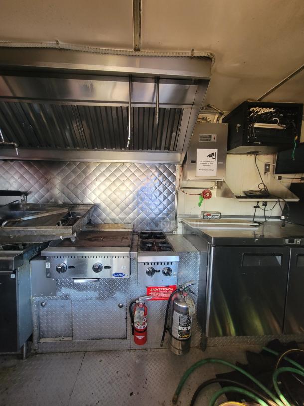 2018 STM 14-Foot Concession Trailer interior with professional kitchen setup, including commercial appliances and fire extinguishers.