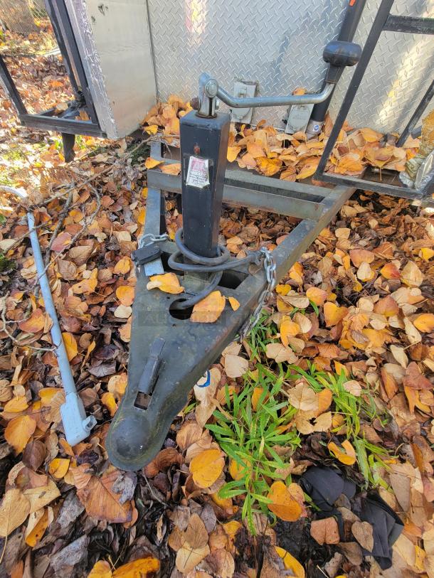 2018 STM 14-Foot Concession Trailer hitch with diamond plate and jack, surrounded by autumn leaves.