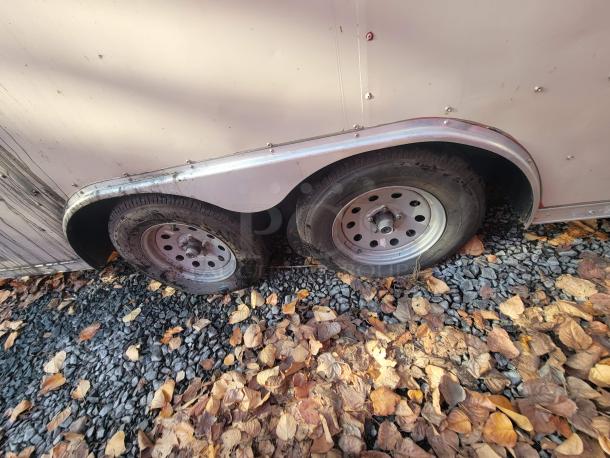 2019 Anvil 16' food trailer tandem axle with visible rust and dirt, parked on gravel with fallen leaves.