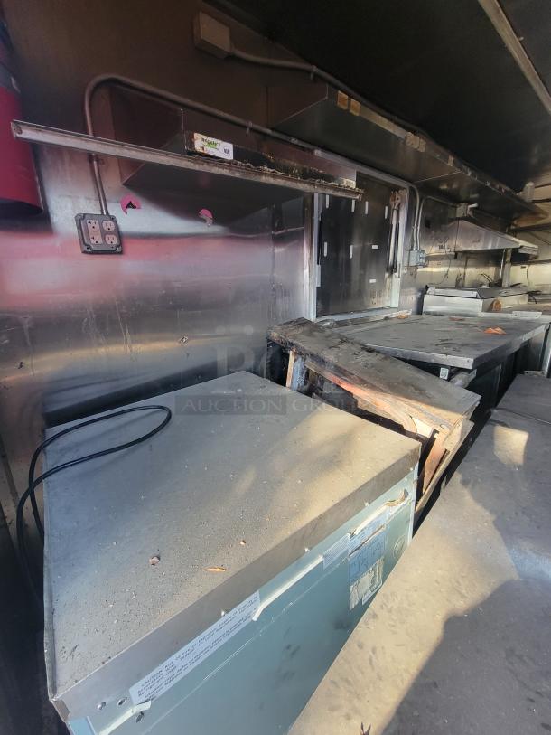 2019 Anvil 16' concession trailer interior with visible fire damage, grease buildup, and soot. Used by "NBRHD KITCHENS."
