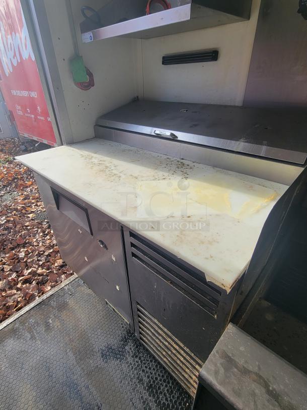 2020 Diamond Cargo 16' food trailer interior with stainless steel counter, shelf, and equipment space; some wear visible.