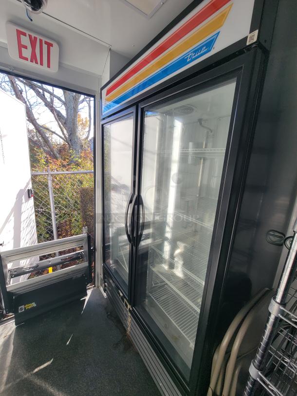 Interior of a 2021 SDG 20' mobile trailer with a True GDM-45-HC-LD cooler, shelves, and exit sign visible.