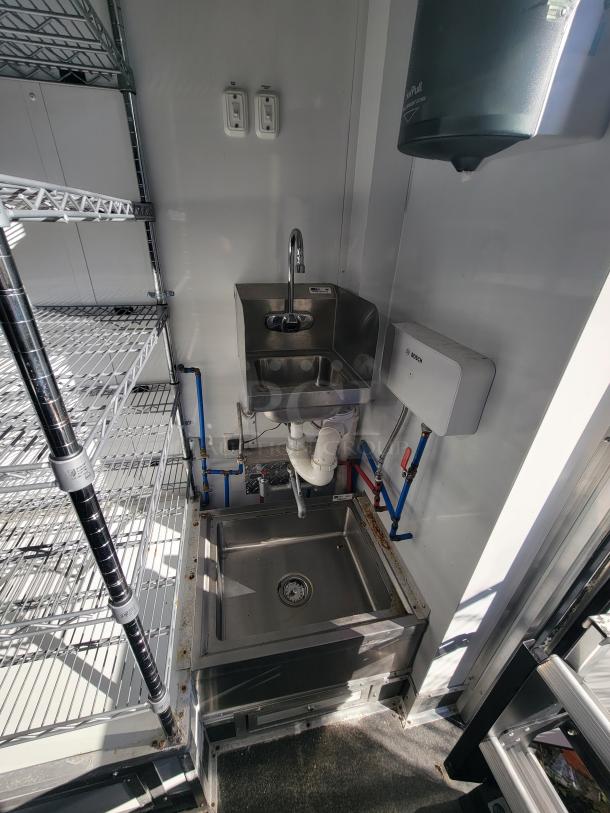 2021 SDG 20-foot trailer interior with stainless steel handwashing station, shelving, and Bosch hot water heater visible.
