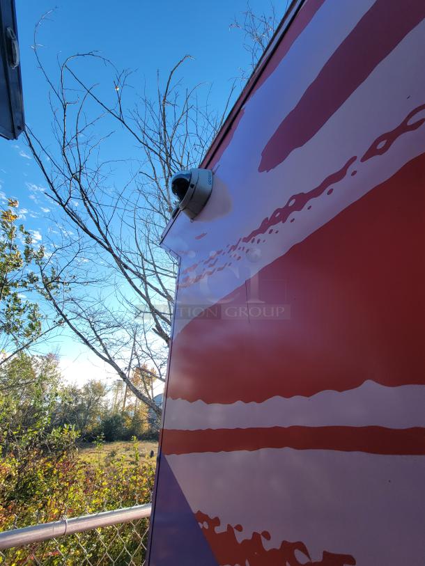 20' SDG food trailer with pink wrap, camera mounted on exterior. Ideal for mobile retail, complete with commercial equipment.