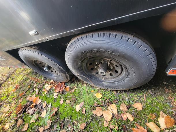 2021 SDG 20' Mobile Market Trailer features dual axle wheels, shown on green mossy ground, indicating sturdy construction.