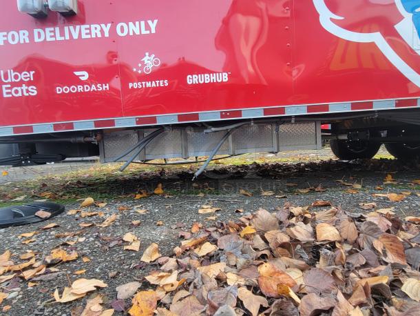 2022 Rock Solid Cargo 28' triple-axle ghost kitchen trailer, red exterior, delivery service logos visible, never used.