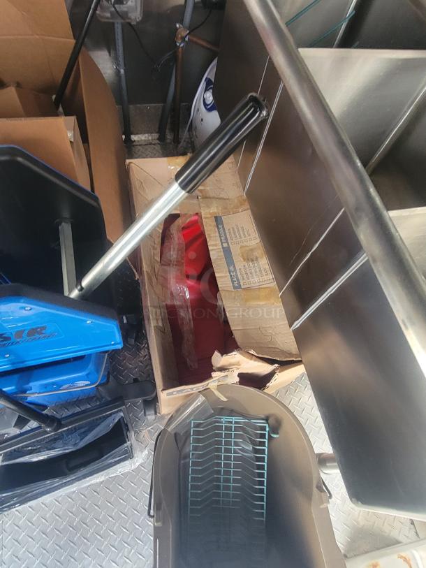 Alt text: Interior of 2022 Rock Solid Cargo ghost kitchen trailer with various packed equipment and stainless steel surfaces.