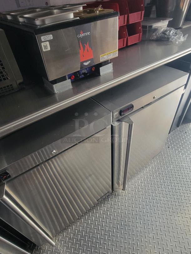 Rock Solid Cargo 28' ghost kitchen trailer interior showing Cayenne warming unit and Turbo Air refrigeration on steel flooring.