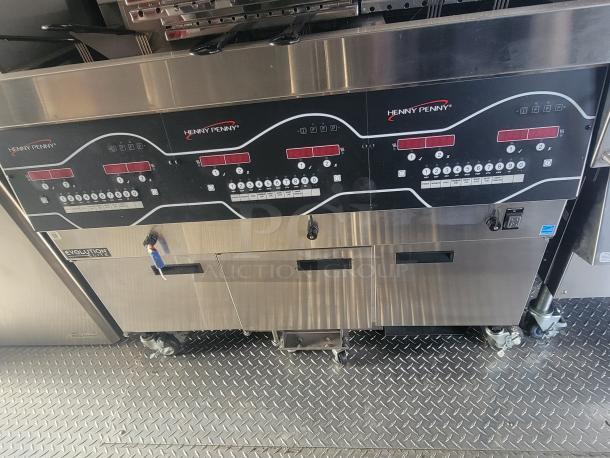 Stainless steel Henny Penny fryer in new condition, equipped with digital controls and branded logo, inside a 2022 ghost kitchen trailer.