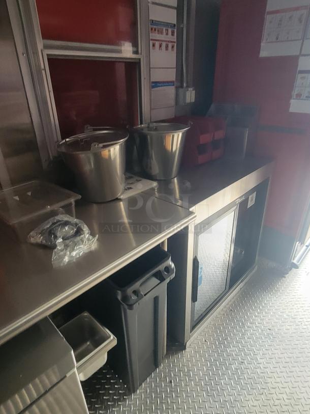 Brand new 2022 Rock Solid Cargo 28' ghost kitchen trailer interior. Stainless steel counters, equipment storage, high-efficiency appliances.