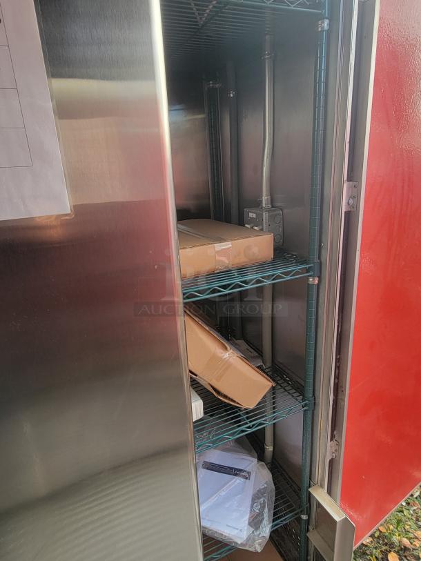 Interior view of a never-used 2022 Rock Solid Cargo 28' ghost kitchen trailer. Features shelving with boxed equipment.