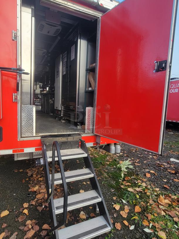 Red Rock Solid Cargo 28' ghost kitchen trailer, new condition. Fully equipped interior with commercial kitchen appliances. Steps lead to open door.