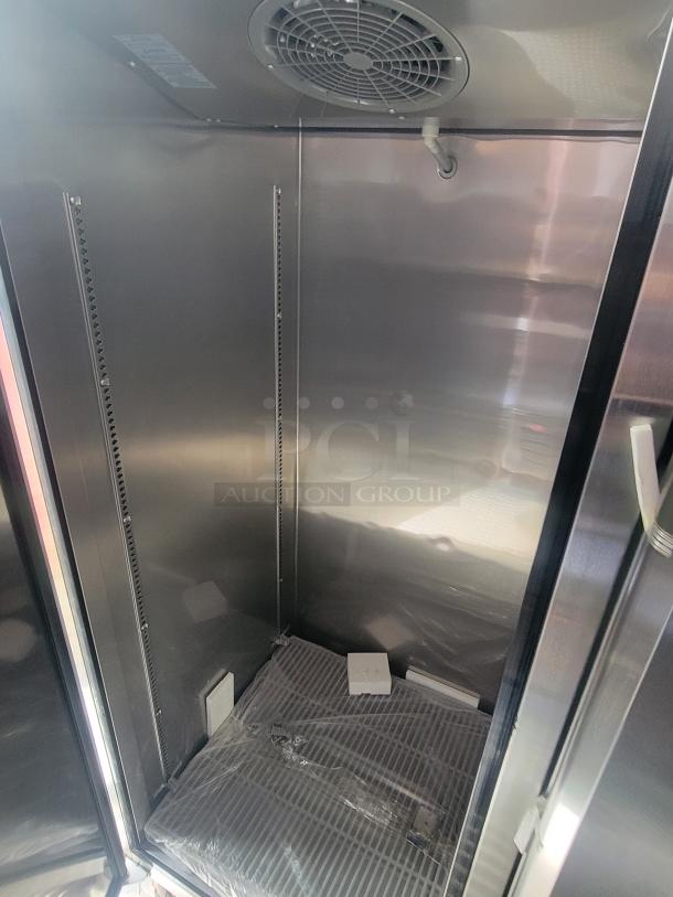 Interior of a brand-new 2022 Rock Solid Cargo ghost kitchen trailer, showcasing stainless steel refrigeration with energy-efficient features and modern design.