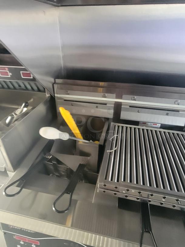 Interior of a 2022 Rock Solid Cargo ghost kitchen trailer showing new Henny Penny fryer, grilling equipment, and utensils.