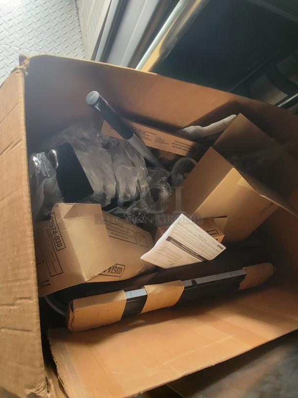 Cardboard box containing new, packaged ghost kitchen equipment parts, possibly related to Rock Solid Cargo trailer.