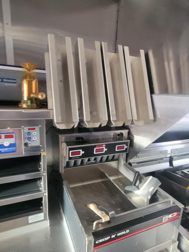 Interior of a 2022 Rock Solid Cargo ghost kitchen trailer featuring a Henny Penny fryer and Antunes toaster. New condition.