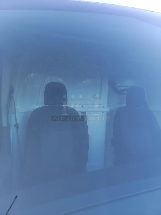 Interior view of a 2020 Ford Transit-350 Van with internal safety partition. Low miles, features commercial configuration.